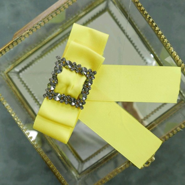 Бант-брошь лимонно-желтого цвета с декором из серых камней и страз