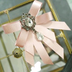 Бант из атласной ленты с золотистым блеском,украшенный брошью