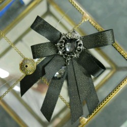 Бант из атласной ленты с золотистым блеском,украшенный брошью