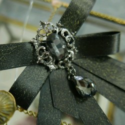 Бант из атласной ленты с золотистым блеском,украшенный брошью