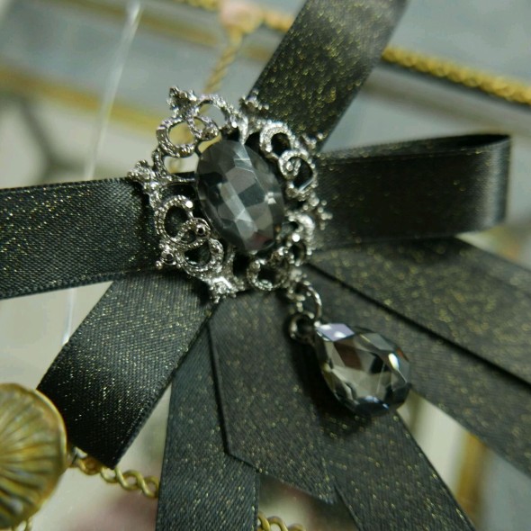 Бант из атласной ленты с золотистым блеском,украшенный брошью