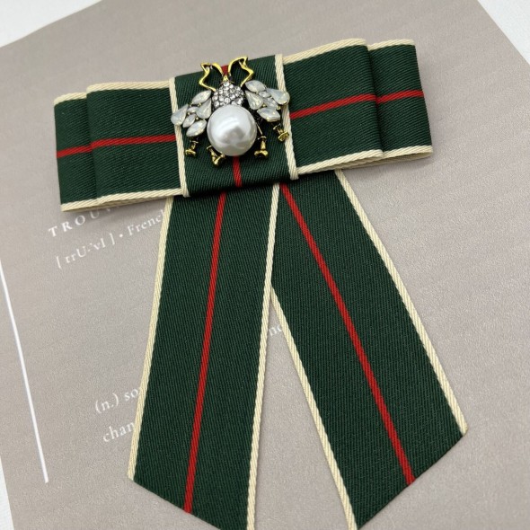 Бант из репсовой ленты в полоску, дополнен брошью