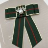 Бант из репсовой ленты в полоску, дополнен брошью