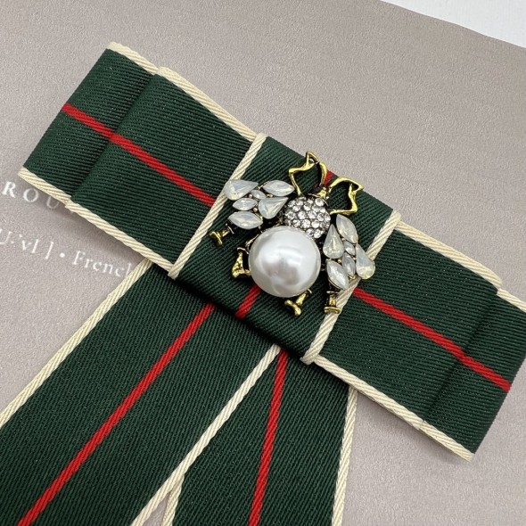 Бант из репсовой ленты в полоску, дополнен брошью