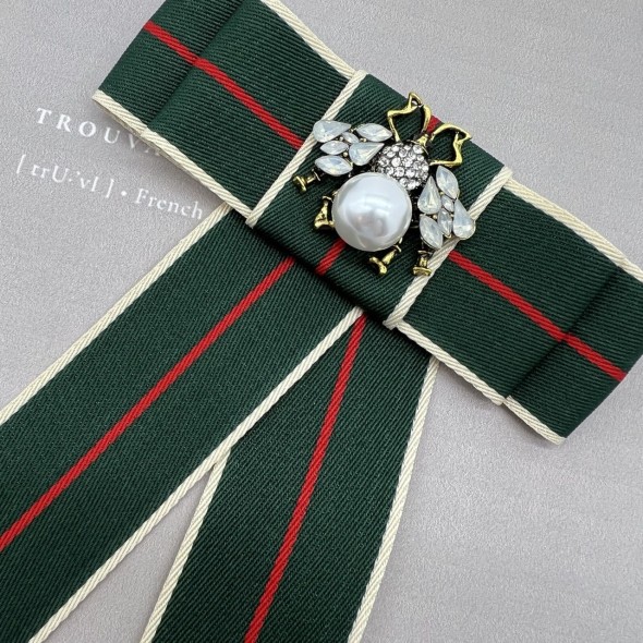 Бант из репсовой ленты в полоску, дополнен брошью