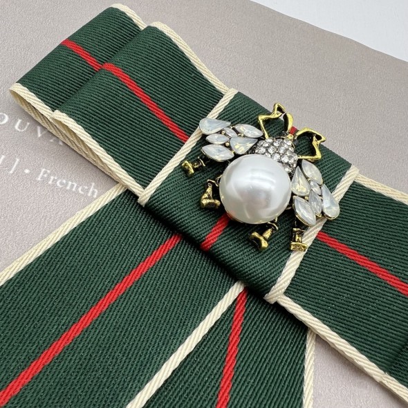 Бант из репсовой ленты в полоску, дополнен брошью