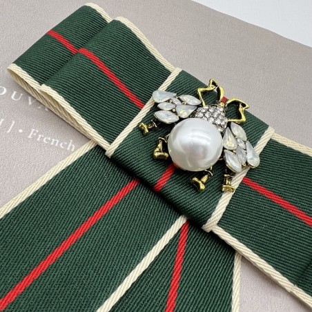 Бант из репсовой ленты в полоску, дополнен брошью