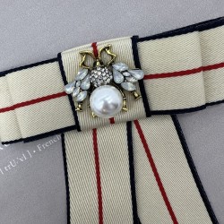 Бант из репсовой ленты в полоску, дополнен брошью