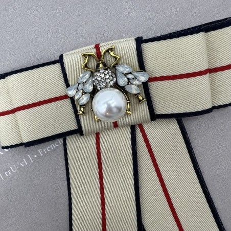 Бант из репсовой ленты в полоску, дополнен брошью