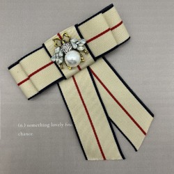 Бант из репсовой ленты в полоску, дополнен брошью