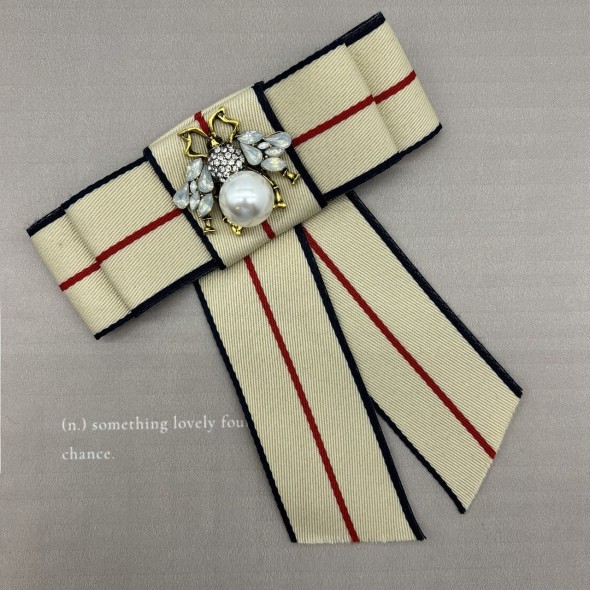Бант из репсовой ленты в полоску, дополнен брошью
