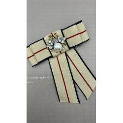 Бант из репсовой ленты в полоску, дополнен брошью