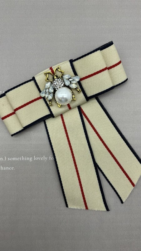 Бант из репсовой ленты в полоску, дополнен брошью